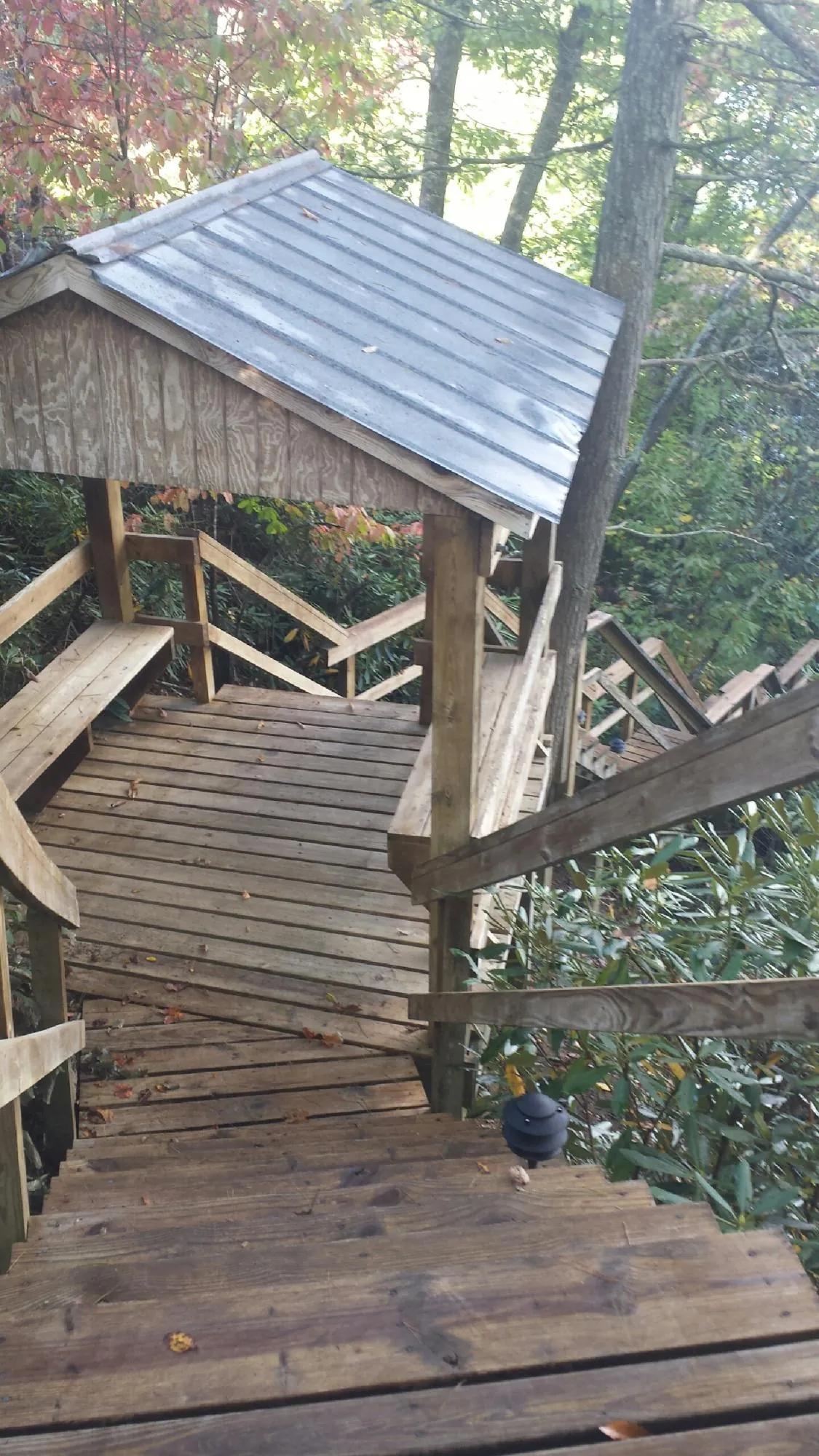Metal roofed shelter over wooden steps on a wooded walkway — Skylight Repair & Installation work by our crew in Palmyra