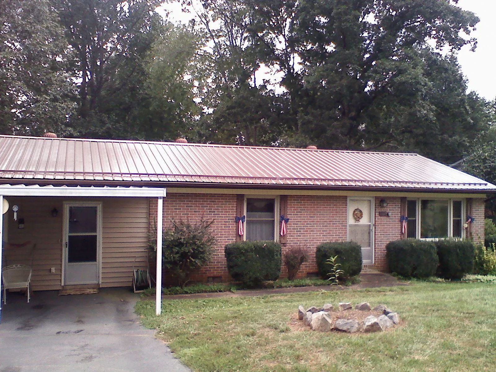 Bronze metal roof and carport on a brick ranch home — Roof Repair work by our crew in Palmyra